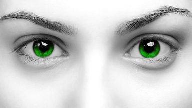 Black and white stock photo of a woman's eyes close up. The eye color has been changed from greyscale to deep emerald green.