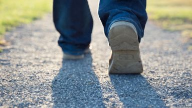 Stock image of a persons shoes walking a gravel path