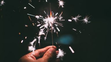 Photograph of a hand holding a lit sparkler