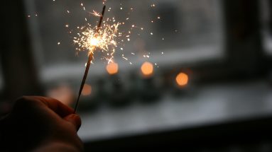 Stock image of a hand holding a lit sparkler