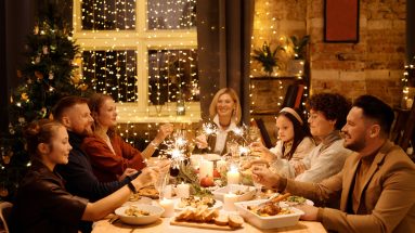 Stock photo of a family enjoying a holiday dinner and celebrating with sparklers